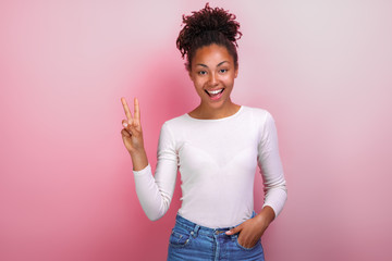 Wall Mural - Attractive young woman showing victory gesture and look happily