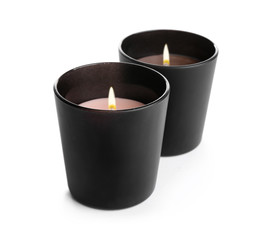 Aromatic burning candles in black holders isolated on white