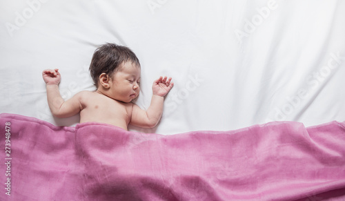 Closeup Portrait Of Asian Baby Sleeping Over White Bed Cover Pink
