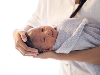 Mother bath Asian boy baby newborn on the bathtub