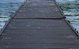 Fototapeta Pomosty - Wooden jetty going into the water