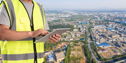 Canvas Print - worker working on pad with oil and gas refinery background,Smart factory concept.