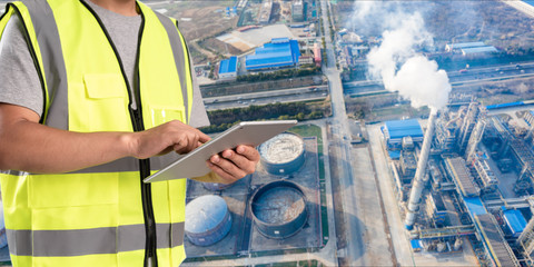 Canvas Print - worker working on pad with oil and gas refinery background,Smart factory concept.