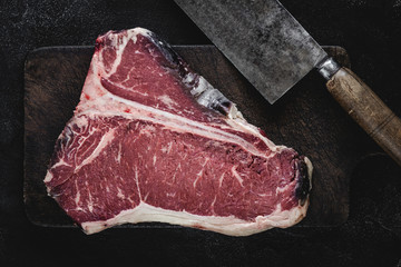 T-bone Steak Raw Dry Aged Beef on Vintage Cutting Board