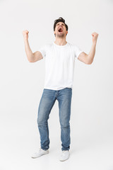 Canvas Print - Excited happy young man posing isolated over white wall background.