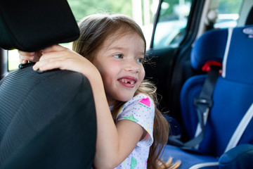 little happy toothless girl in the car