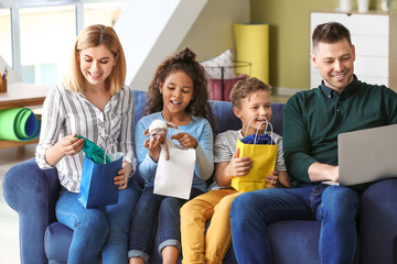 Wall Mural - Happy couple with little adopted children after shopping at home