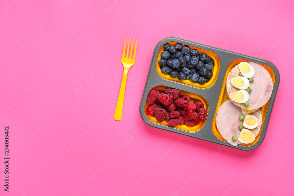School lunch box with tasty food on color background