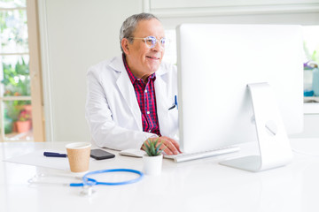 Poster - Senior doctor man at the clinic working with computer and smiling