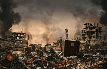 homeless little boy watching destroyed houses and bombarded city between smoke.