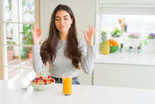 Young Woman Eating Healthy Breakfast In The Morning Relax And Smiling With Eyes Closed Doing Meditation Gesture With Fingers. Yoga Concept.