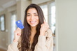 © Krakenimages.com - Young woman holding credit card as payment screaming proud and celebrating victory and success very excited, cheering emotion