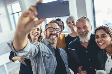 Wall Mural - Multiracial group of people taking selfie at office