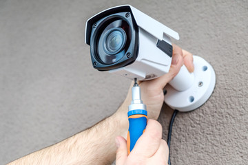 Close-up hands of technician adjusting CCTV camera