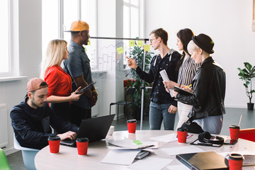 Wall Mural - Multiethnical Business people in casual clothes meeting at office and use post it notes to share idea. Brainstorming concept. Sticky note on glass wall.