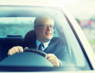 Canvas Print - transport, business trip and people concept - happy senior businessman driving car