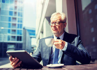 Canvas Print - business, technology and people concept - senior businessman with tablet pc computer drinking coffee at city street cafe