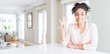 © Krakenimages.com - Wide angle of beautiful african american woman with afro hair showing and pointing up with fingers number four while smiling confident and happy.