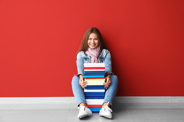 Sticker - Beautiful young woman with books near color wall