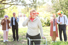 Happy Disabled Senior Woman Celebrating Birthday In Park