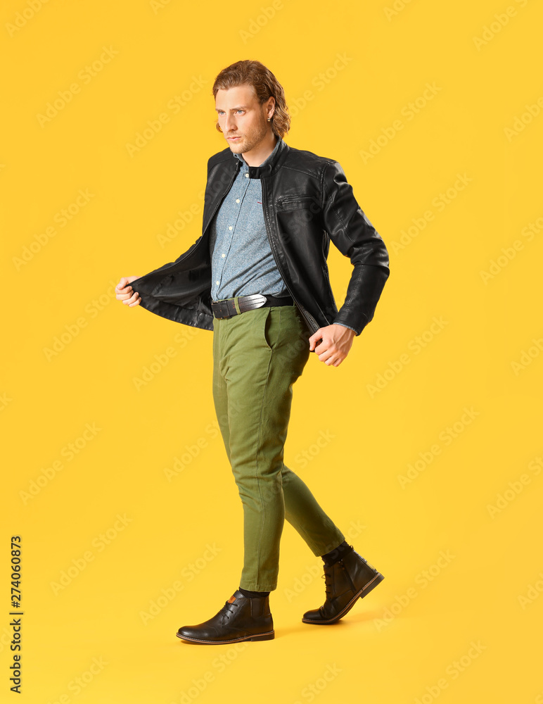 Stylish young man in casual clothes on color background