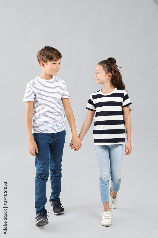 Stylish children in jeans on grey background