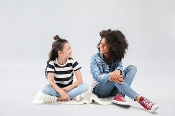 Wall Mural - Stylish girls in jeans on grey background