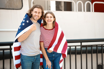 Wall Mural - Happy young couple with USA flag on embankment. Independence Day celebration