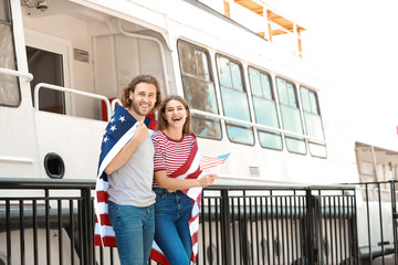 Wall Mural - Happy young couple with USA flag on embankment. Independence Day celebration