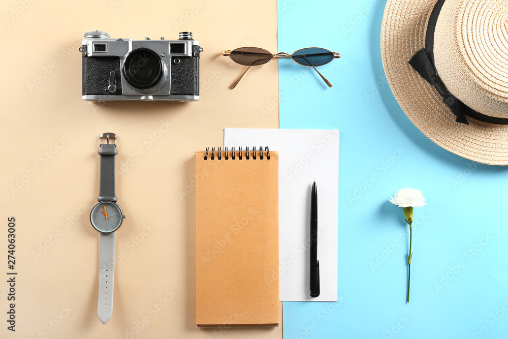 Photo camera, sunglasses, notebook, watch and hat on color background