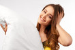 © EverGrump - Large Studio portrait on a white background of a young woman with long colored hair in a nightie. She hugs the pillow and smiles a snow-white smile. The concept of a happy comfortable healthy sleep