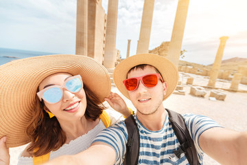 Young loving couple of tourists or friends travelers visiting ancient landmark Acropolis in Greece