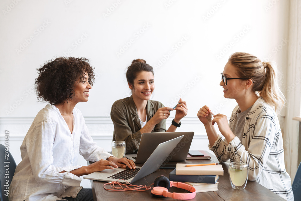 Group of cheerful young women studying together - obrazy, fototapety, plakaty 