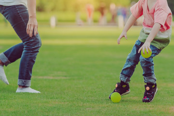 Wall Mural - Kid enjoy to playing with little ball on green field