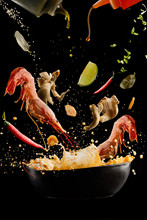 Flying Soup Tom Yam With Shrimp And Spices. Concept Of Food Preparation In Low Gravity Mode, Food Levitation. Separated On Black Background. High Resolution Image