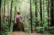 © Ursula Page - Teen Teen Girl Sitting on a Stump Looking Out into a green Forest full of trees