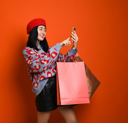 Woman holding shopping bag and using smartphone for shopping online, shopping concept.