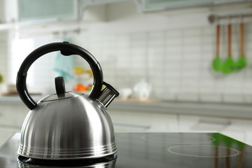 Poster - Modern kettle with whistle on stove in kitchen, space for text