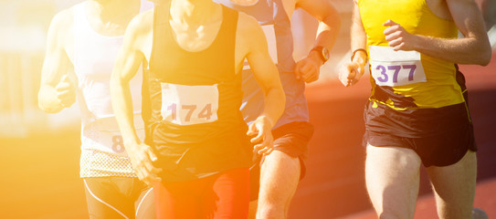 Athletics people running on the track field. Sunny day