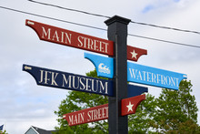 Colorful Red And Blue Street Sign In Hyannis, Massachusetts With Directions To Main Street, Waterfront, And JFK Museum,