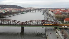 4K Aerial Drone Following Vlak Zeleznicni Train As It Crosses A Bridge Suspended Over Water Into The Other Side Of Beautiful Prague