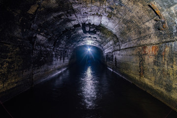 Canvas Print - Dark flooded concrete vaulted drainage mine tunnel