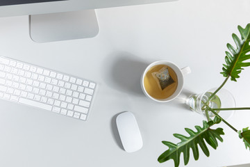 Overhead shot of business desktop with computer and cup of tea