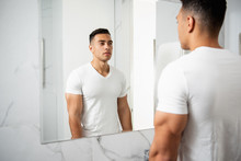 Back Side Portrait Of Young Man Looking At Mirror