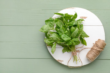 Fresh basil and thread on wooden background