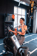 © Viacheslav Yakobchuk - Dark-haired woman cycling in gym and speaking on phone