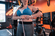 Plump woman wearing fitness tracker measuring waistline