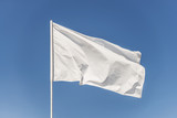 Fototapeta Tulipany - White flag against the blue sky