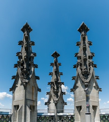 Poster - the spires of the historic cathedral in Fribourg under a blue sky with white clouds