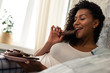 © Viacheslav Yakobchuk - Happy woman enjoying her chocolate bar in bed.